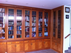 Librería clásica en madera de cerezo y vitrinas. Vista rincón. 